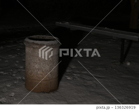 concrete trash can covered with snow on a night alley 136326919