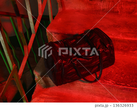 black sports bag on steps under red lighting black sports bag on steps under red lighting 136326933