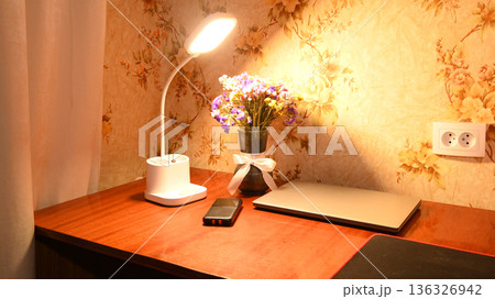 a workplace with a desk lamp a bouquet of dried flowers and a laptop on a wooden table a workplace with a desk lamp a bouquet of dried flowers and a laptop on a wooden table 136326942