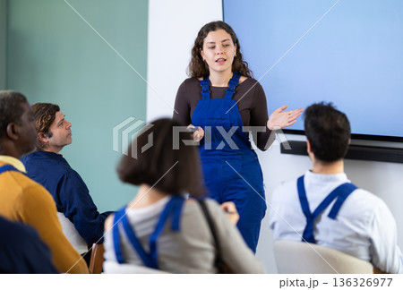Young woman worker gives lecture in auditorium 136326977