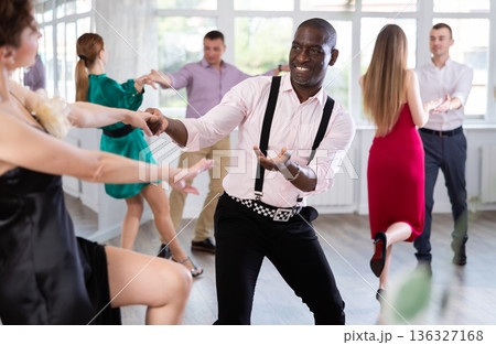 Woman dances incendiary boogie woogie with African man partner during choreography lesson Woman dances incendiary boogie woogie with African man partner during choreography lesson 136327168