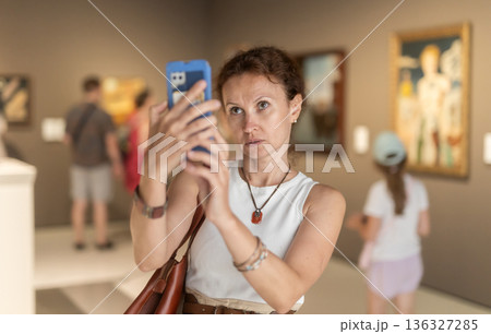Adult woman taking photo of art gallery 136327285