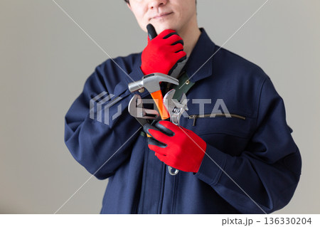 工具を持って悩む作業服のミドル男性ビジネスマン 136330204