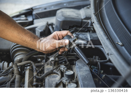 Close up Car Mechanic man hands repairing car auto repair shop. Man hands fixing machinery vehicle mechanical service. open vehicle hood checking up auto mobile. Vehicle Car maintenance engineer. 136330416