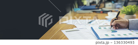 Asian Female freelance using laptop at home office desk. Woman reading financial graph chart Planning analyzing marketing data. Asian female people working office firm with business stuff, coffee cup 136330493