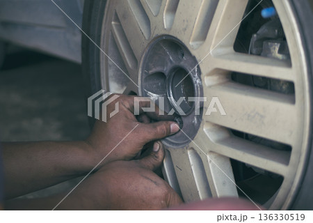 Mechanic man hands checking car tires outdoor on site service auto garage for automotive mobile center services. Technician workshop repair checking tyres car motor vehicles service mechanical hands 136330519