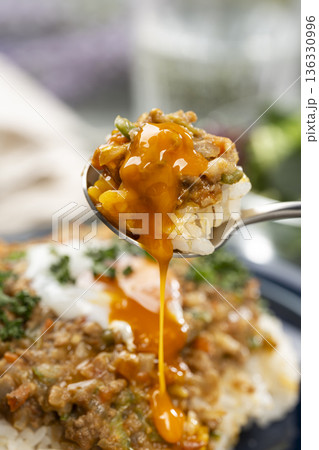 半熟卵をのせたキーマカレーをスプーンで掬って食卓でたべる 半熟卵をのせたキーマカレーをスプーンで掬って食卓でたべる 136330996