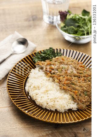 食卓に並ぶスパイス香るドライカレーと白ご飯の家庭料理 136331001