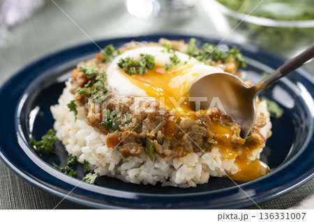 食卓でスパイスの効いた半熟卵のせキーマカレーをスプーンで食べる 食卓でスパイスの効いた半熟卵のせキーマカレーをスプーンで食べる 136331007