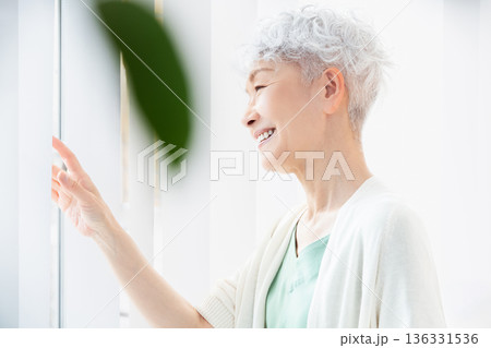朝の窓辺で過ごすシニア女性 136331536