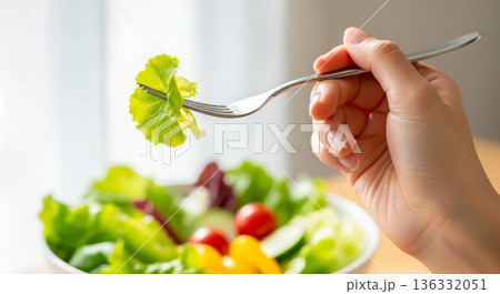 新鮮なサラダをフォークですくい上げる食事シーン 新鮮なサラダをフォークですくい上げる食事シーン 136332051
