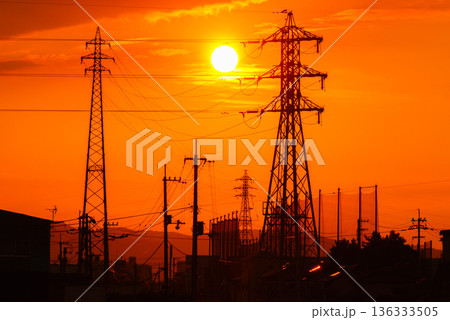 夕焼けの太陽と送電線のシルエット　電力インフラと都市風景 136333505