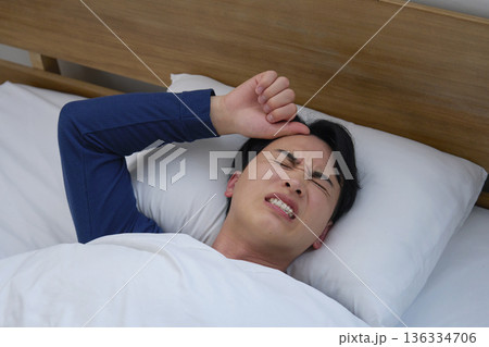 ベッドで眠る男性 20代 発熱 ベッドで眠る男性 20代 発熱 136334706