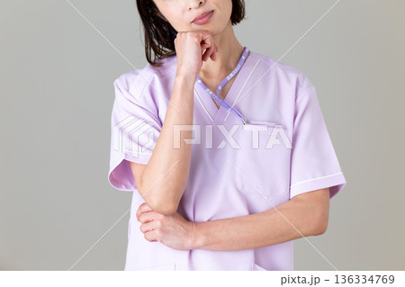 悩む医療用スクラブ姿のミドル女性看護師 悩む医療用スクラブ姿のミドル女性看護師 136334769