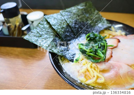 濃厚スープに海苔が立つ家系ラーメンの一杯 136334816