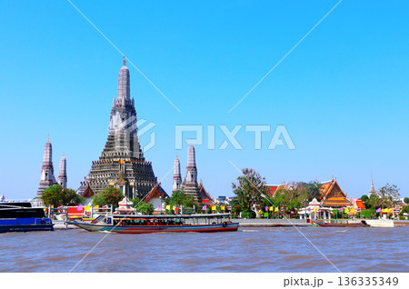 Buddhist Temple of Dawn Wat Arun, sightseeing landmark of Bangkok, Thailand. Famous tourist attraction boat ride on Chao Phraya river. Summer vacation, relaxing, topic of travel, trip, cruises, tour 136335349