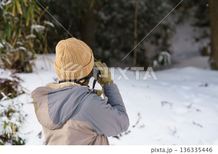 冬の野外で双眼鏡を覗く女性の後姿 冬の野外で双眼鏡を覗く女性の後姿 136335446
