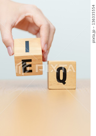 hand change wooden block from IQ to EQ, balance between intelligence quotient and emotional quotient, AQ Adversity, MQ, Moral, SQ and Social quotient concepts 136335554