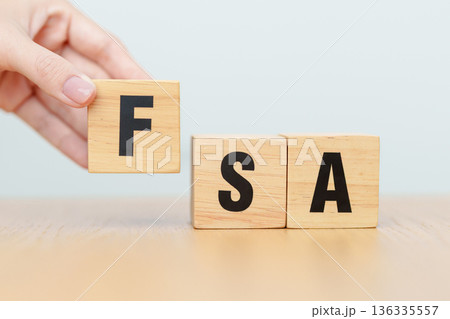 hand change wooden block of FSA. HSA, Flexible Spending Account and Health Savings Account, Medical Expenses, Tax Benefits and healthcare concepts hand change wooden block of FSA. HSA, Flexible Spending Account and Health Savings Account, Medical Expenses, Tax Benefits and healthcare concepts 136335557