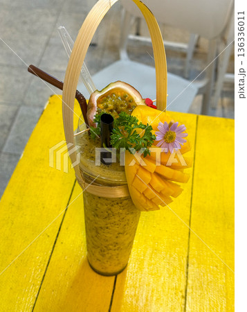 Tropical Mango Passion Fruit Smoothie With Fresh Herbs on Yellow Table 136336011