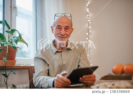 Elderly man using tablet, shopping online. Elderly man using tablet, shopping online. 136336669