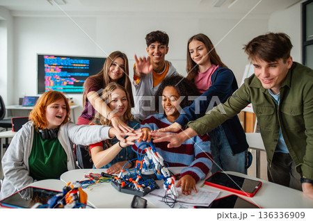 Teen students working as a team on robotics project in classroom. 136336909