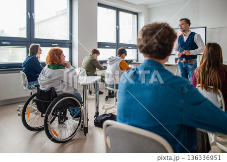 Inclusive classroom scene with student using wheelchair. Inclusive classroom scene with student using wheelchair. 136336951