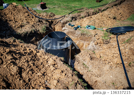 Installing underground utility shaft during construction work. Installing underground utility shaft during construction work. 136337215