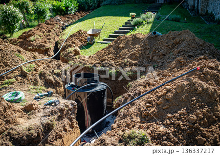 Installing underground utility shaft during construction work. 136337217