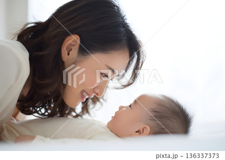赤ちゃんと見つめ合う母親の優しい育児シーン 愛情あふれる親子の時間 136337373