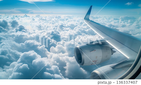 雲海の上を飛ぶ飛行機の翼と青空に広がる空の旅 136337407