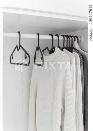 Wardrobe with sweaters on hangers 136337615
