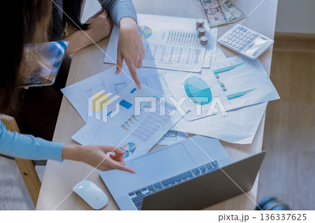 Team of partners Asian business woman discussing project on laptop sitting at table in office. 136337625