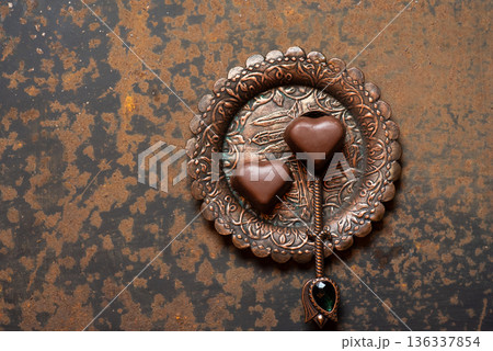 Two Heart-Shaped Chocolates On Decorative Copper Plate 136337854
