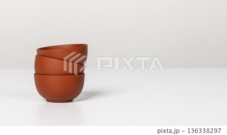 Stack of three small ceramic cups, bowls on table. Banner background with kitchen ware. Banner 136338297