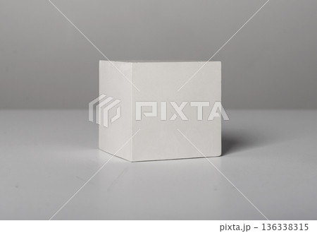 white cube with clean straight edges placed on a neutral studio surface. Simple geometric solid with 136338315