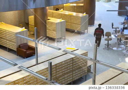Interior view of a large archive or library space with rows of wooden card catalog cabinets and Interior view of a large archive or library space with rows of wooden card catalog cabinets and 136338336
