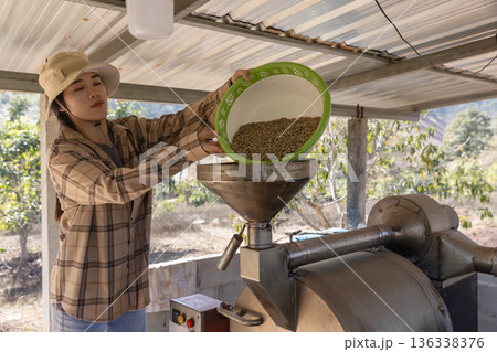 Coffee processing. Coffee roasting machine with arabica beans in stainless steel cooling bin. 136338376