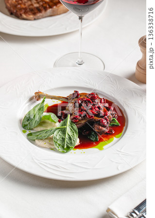 Duck confit leg with berry sauce 136338716