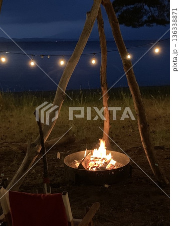 湖畔のキャンプファイヤーとガーランドライトのある夜 136338871