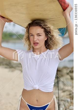 Relaxed Woman In Sunlit Setting. Calm Female Figure With Knotted Shirt Smiling On Warm Sunny Shore Relaxed Woman In Sunlit Setting. Calm Female Figure With Knotted Shirt Smiling On Warm Sunny Shore 136338935