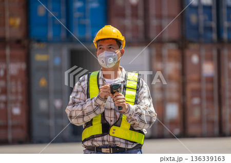 Foreman or worker work at Container cargo site check up goods in container. Foreman or worker work at Container cargo site check up goods in container. 136339163