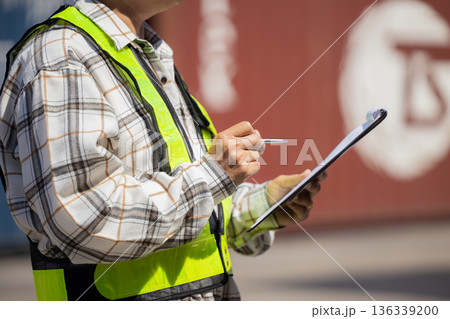 Foreman or worker work at Container cargo site check up goods in container. Foreman or worker work at Container cargo site check up goods in container. 136339200