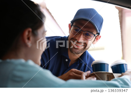 Hand Man in car receiving coffee in drive thru fast food restaurant.  136339347