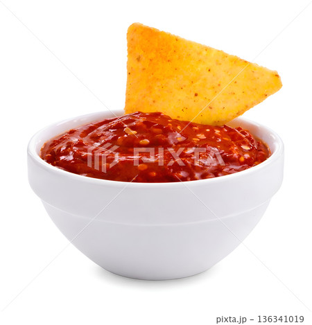 Nacho Chip Dipping in Spicy Chili Sauce 136341019