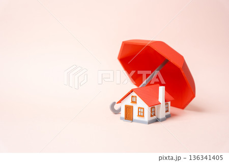 A residential building under a red umbrella. Property insurance. Home protection planning covers damage and disasters. Financial security shields owners and long term investment. 136341405
