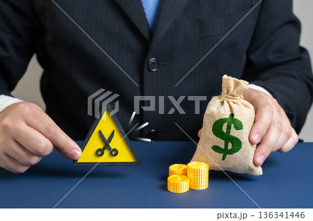 A businessman or official cuts the budget. Reduce costs and save money. Financial optimization concept about crisis response. Smart spending control and corporate efficiency strategy. 136341446