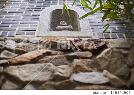 Buddha statue in wall niche with stone and brick texture 136341607
