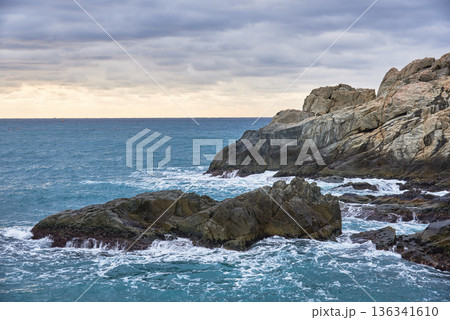 Rugged rocky coastline with waves under overcast sky Rugged rocky coastline with waves under overcast sky 136341610