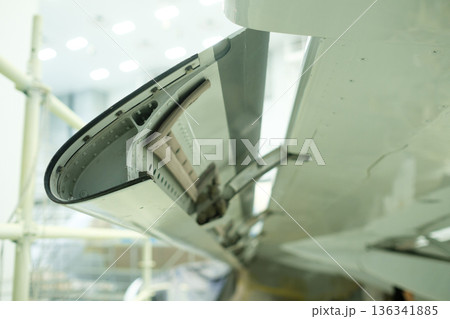 an aircraft wing flap mechanism showing the maintenance conditions of an aircraft with tools and equipment in the background during daytime an aircraft wing flap mechanism showing the maintenance conditions of an aircraft with tools and equipment in the background during daytime 136341885